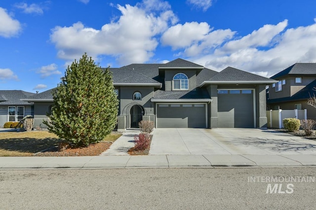 view of front facade featuring driveway, a garage, fence, and stucco siding