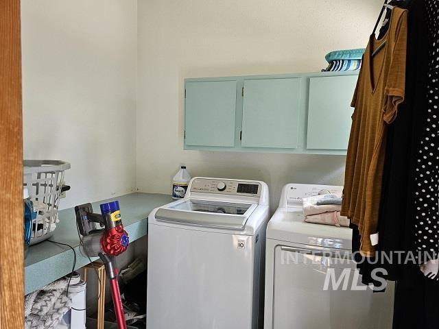 laundry room with cabinets and washing machine and clothes dryer