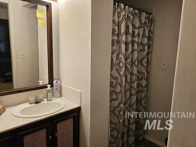 bathroom featuring walk in shower and vanity