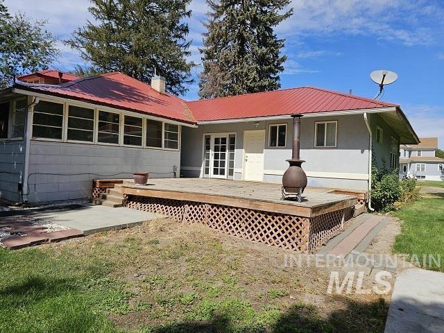 rear view of property with a wooden deck and a yard