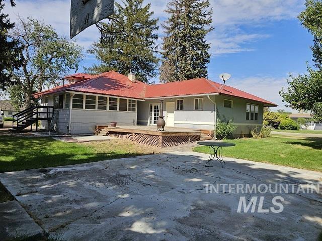 rear view of house with a patio, a yard, and a deck