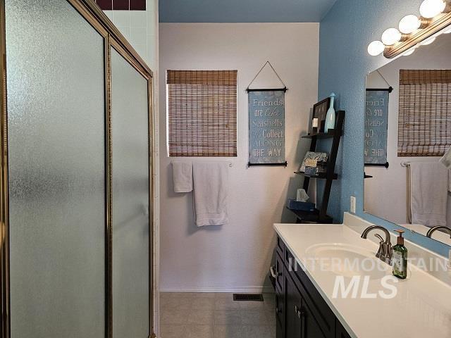 bathroom featuring an enclosed shower and vanity