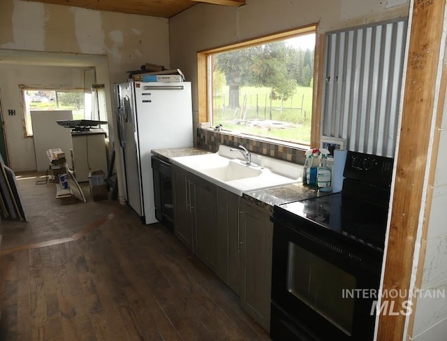 kitchen with sink, dark wood-type flooring, and black appliances