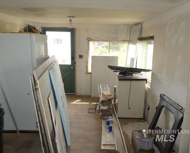 interior space featuring white refrigerator and white cabinetry