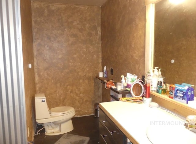 bathroom featuring tile patterned flooring, vanity, and toilet