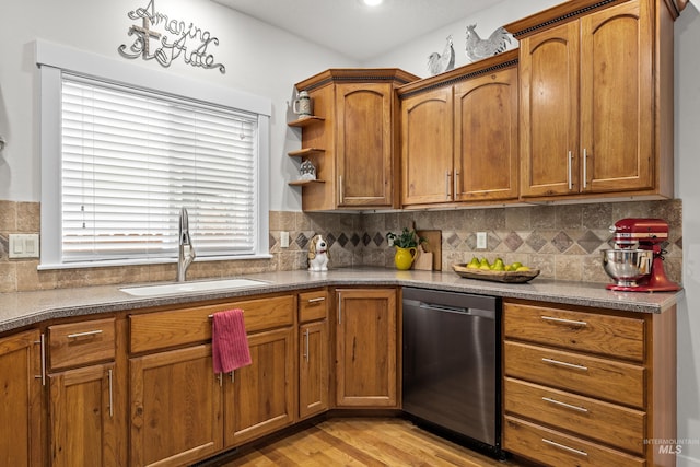 kitchen with stainless steel dishwasher, sink, light hardwood / wood-style flooring, and backsplash