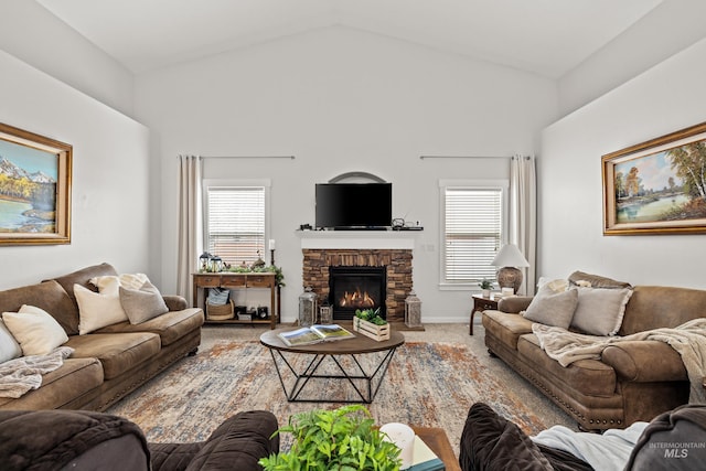 living room with a healthy amount of sunlight, a stone fireplace, carpet flooring, and high vaulted ceiling