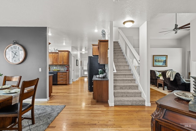 interior space featuring ceiling fan, a textured ceiling, and light wood-type flooring