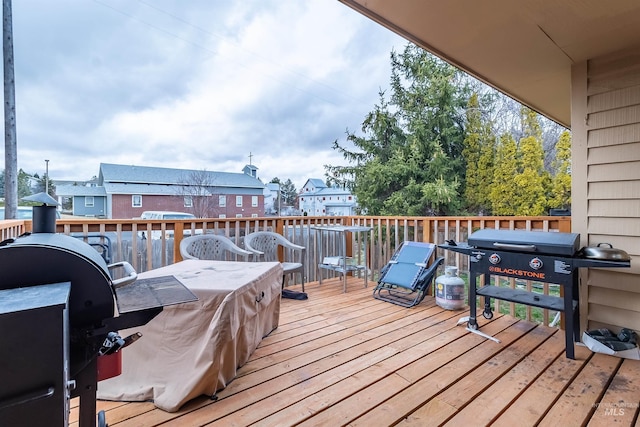 wooden terrace with a residential view and a grill