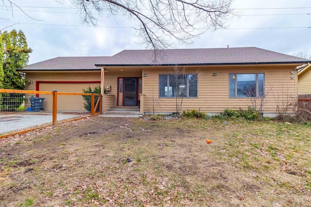 ranch-style home featuring roof with shingles, a garage, and fence