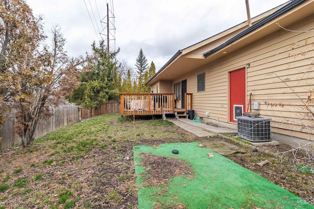 view of yard featuring a wooden deck, central AC unit, and fence