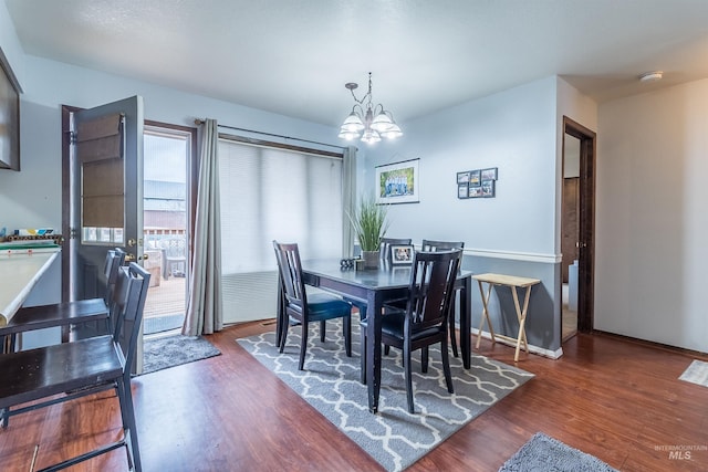 dining space featuring a notable chandelier, baseboards, and wood finished floors