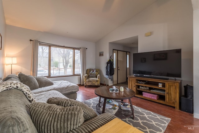 living area with wood finished floors and high vaulted ceiling