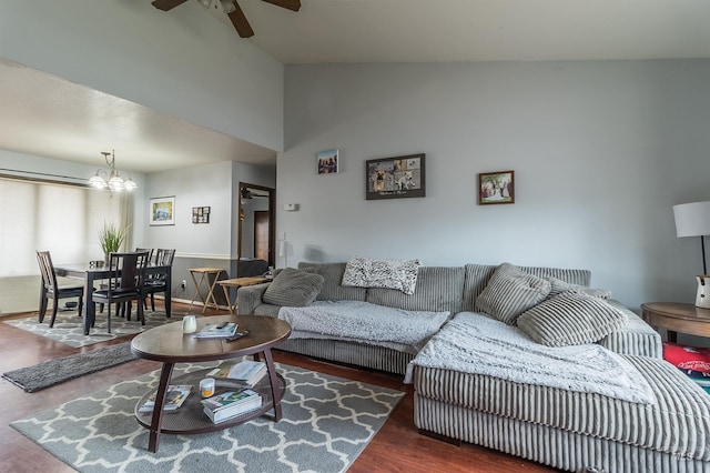 living room with lofted ceiling, wood finished floors, and ceiling fan with notable chandelier