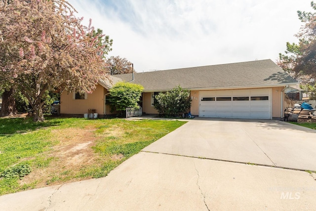 ranch-style home featuring a garage, a front lawn, and driveway
