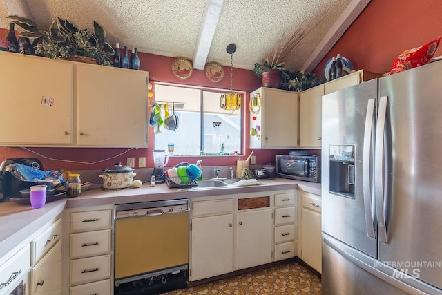 kitchen with a textured ceiling, pendant lighting, a sink, appliances with stainless steel finishes, and light countertops