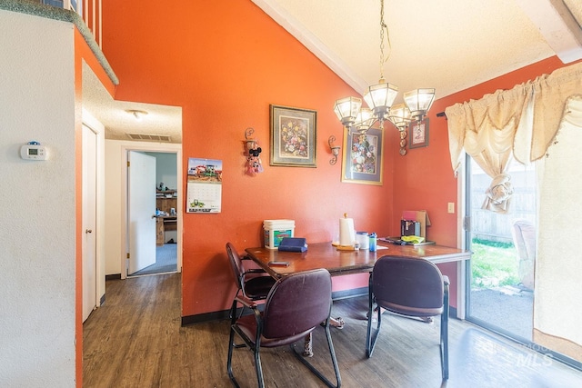 dining room featuring a notable chandelier, visible vents, wood finished floors, and lofted ceiling