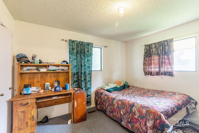 bedroom featuring a textured ceiling and carpet floors