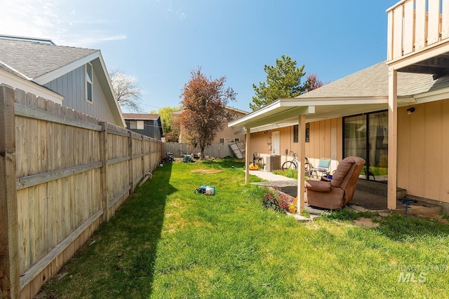 view of yard featuring a patio, a fenced backyard, and central AC unit