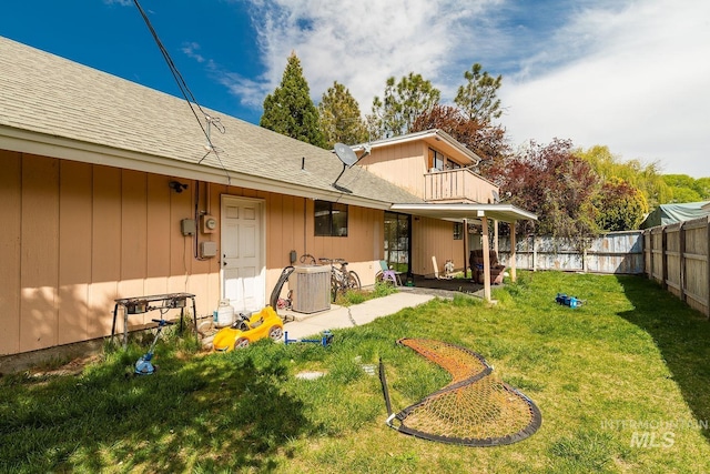 back of property featuring cooling unit, a lawn, and a fenced backyard