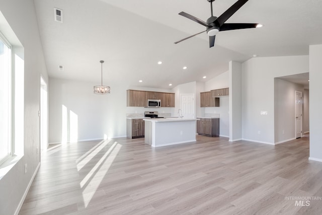 unfurnished living room with light hardwood / wood-style floors, ceiling fan with notable chandelier, and vaulted ceiling