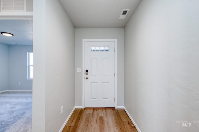 entryway featuring light wood-type flooring and a textured ceiling