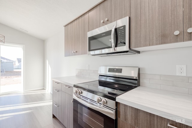 kitchen with stainless steel appliances and lofted ceiling