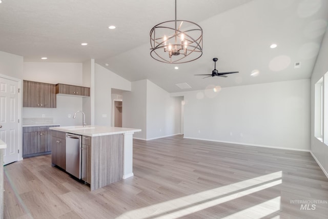 kitchen with sink, hanging light fixtures, vaulted ceiling, stainless steel dishwasher, and a center island with sink