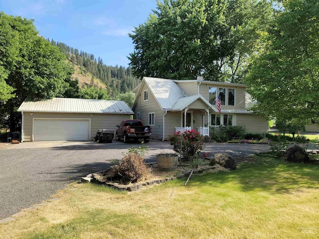 27406 Gem Ln, Juliaetta, ID 83535 - view of front of house with an outdoor structure, a front yard, a garage, gravel driveway, and a metal roof