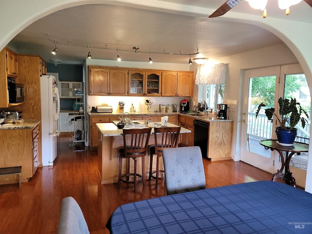 27406 Gem Ln, Juliaetta, ID 83535 - kitchen featuring black appliances, a kitchen island with sink, arched walkways, and dark wood-style flooring