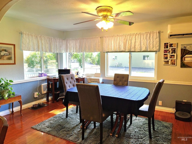 27406 Gem Ln, Juliaetta, ID 83535 - dining space featuring a wall unit AC, wood finished floors, ceiling fan, and a textured wall