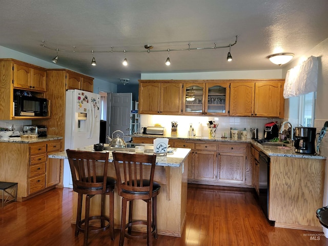 27406 Gem Ln, Juliaetta, ID 83535 - kitchen featuring black appliances, dark wood-style flooring, brown cabinetry, light stone counters, and a center island