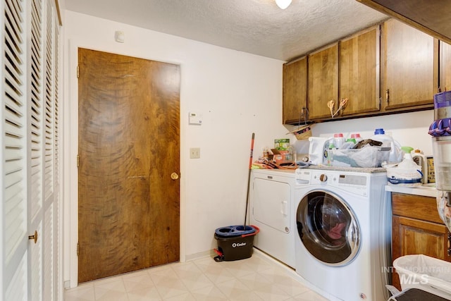 11360 W Lake Hazel Rd, Boise, ID 83709 - laundry room featuring separate washer and dryer, cabinet space, a textured ceiling, and light floors