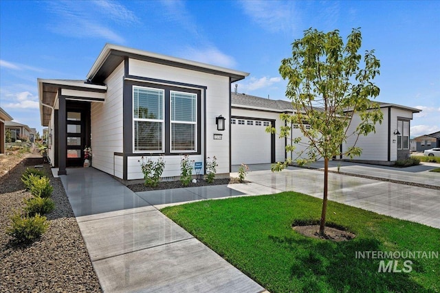 view of front of property featuring a garage and a front lawn