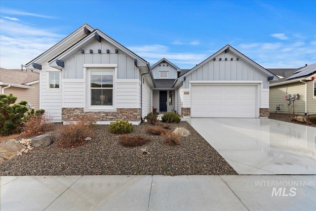 view of front facade featuring board and batten siding, stone siding, driveway, and an attached garage