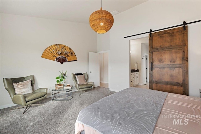 bedroom with a towering ceiling, a barn door, baseboards, and carpet flooring