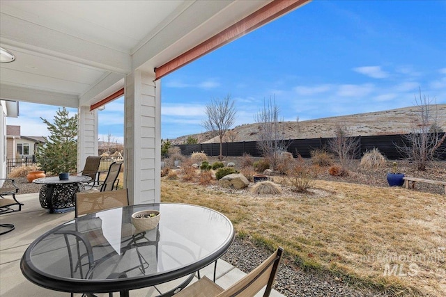 view of patio with outdoor dining space and fence