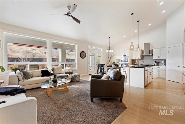 living area with light wood finished floors, high vaulted ceiling, a ceiling fan, and recessed lighting