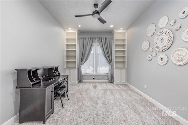 office space with light carpet, ceiling fan, and a textured ceiling