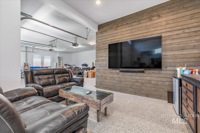 carpeted living room featuring wood walls and beam ceiling