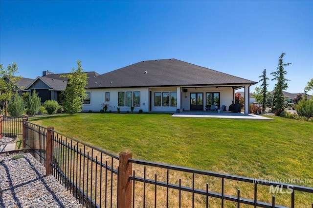 back of house featuring a patio and a lawn