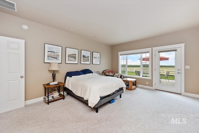 bedroom with light carpet, access to outside, visible vents, and baseboards