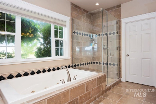 full bathroom with a stall shower, tile patterned flooring, and a jetted tub