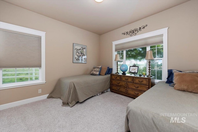 bedroom with light carpet and baseboards