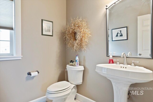 bathroom featuring a sink, toilet, and baseboards