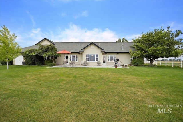 back of property featuring a patio area, fence, stucco siding, and a yard