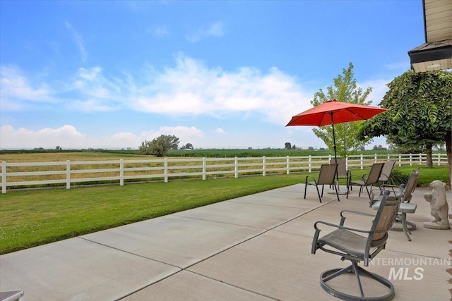 view of patio / terrace featuring a rural view and fence