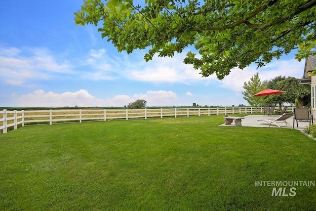 view of yard featuring a rural view, a patio, and fence