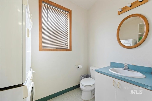 bathroom featuring toilet, baseboards, and vanity