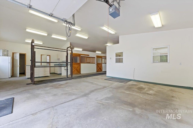 garage featuring a garage door opener and freestanding refrigerator